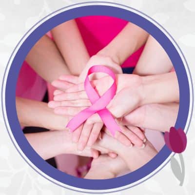 Hands holding a pink breast cancer ribbon