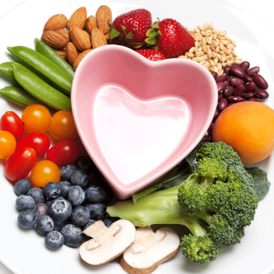 Healthy foods surrounding a heart-shaped bowl, representing nutrition